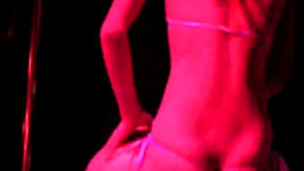 Punases öösärgis veebikaamera mudel demonstreerib lähivaates pudeliga anaalset masturbeerimist.